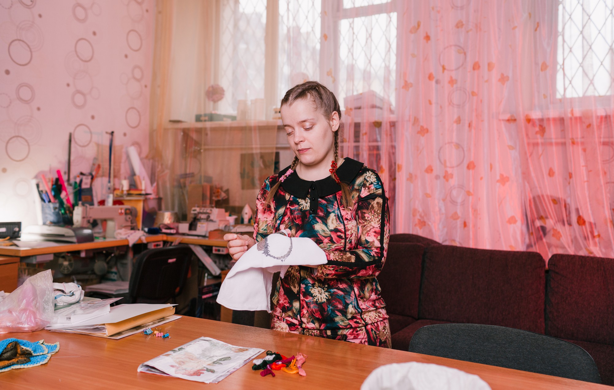 Mokytoja demonstruoja siuvinėjimo techniką